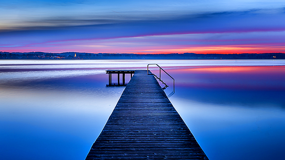 Jetty on Lake Starnberg at sunset with a view of the mountains, St. Heinrich, Bavaria, Germany