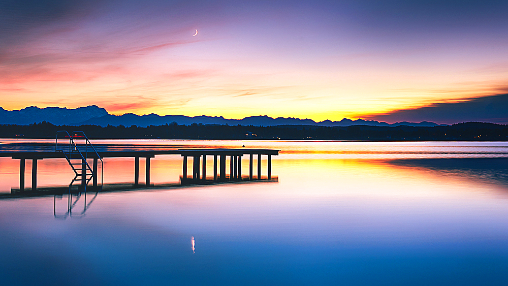 Jetty on Lake Starnberg at sunset with a view of the mountains, St. Heinrich, Bavaria, Germany