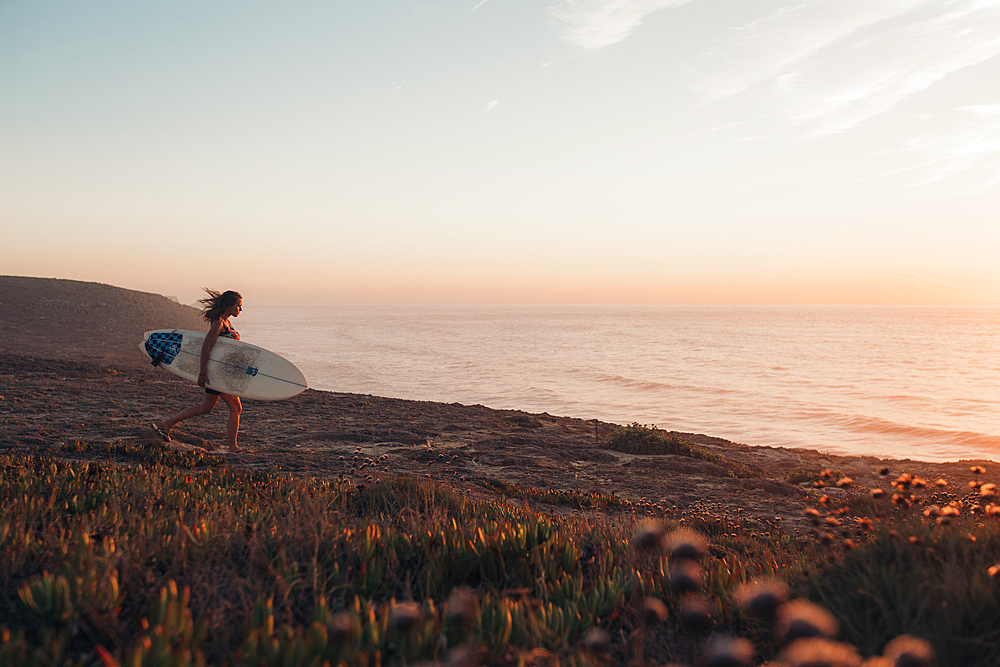 Surfer goes to the sea at sunrise, Portugal, surfing, vacation