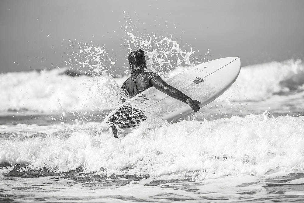 Surfer goes through waves into the water, surfing, portugla, vacation