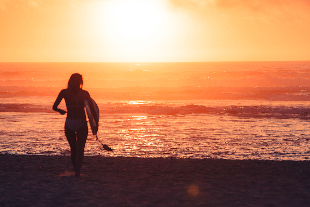 Surfer runs to the sea in sunset, Portugal, surfing, vacation