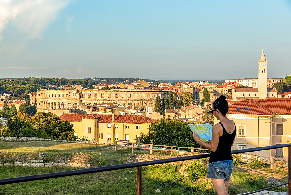 Female tourist with map at ancient Roman Amphitheatre known as Pula Arena, Pula, Istria, Croatia