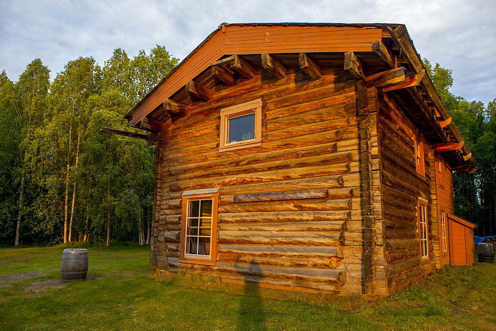 Slaven's Roadhouse, on a sunny, summer night with shadow of person waving, Yukon–Charley Rivers National Preserve, Yukon River, Alaska, United States of America