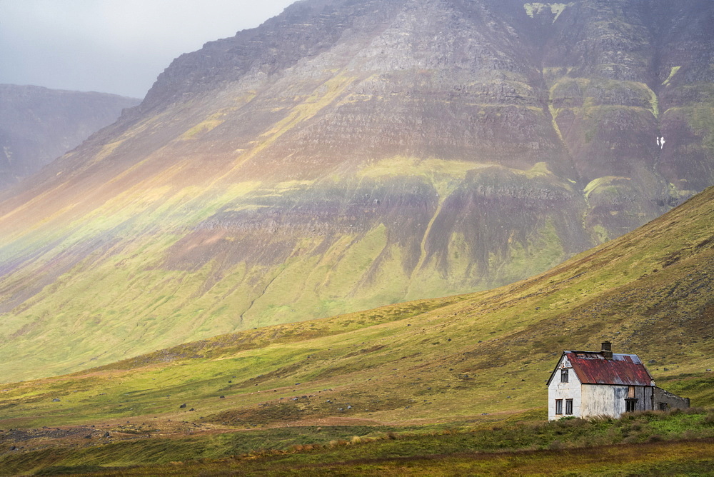 Faint rainbow over an abandoned Iceland homestead, West Fjords, Iceland