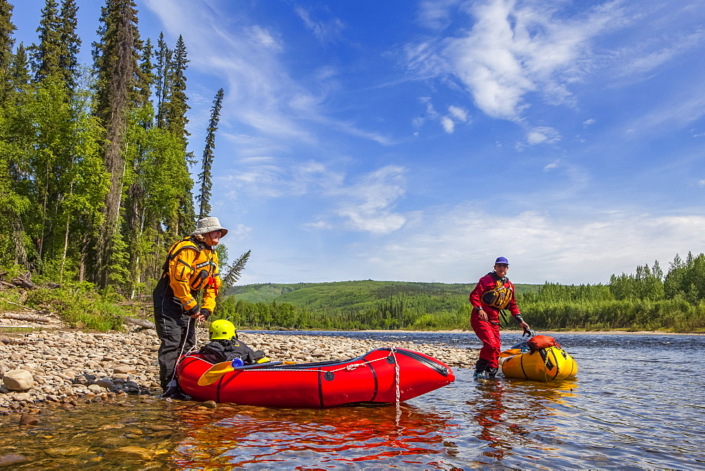 Two women packrafters getting ready to launch on the Charley River in summertime, Yukon–Charley Rivers National Preserve, Alaska, United States of America