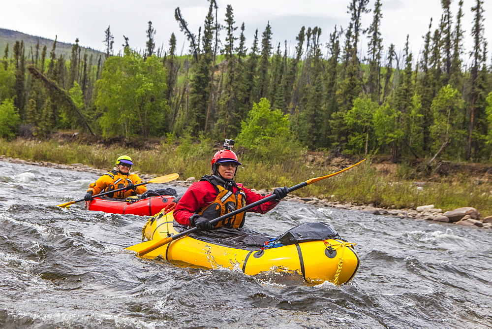 Two women packrafters negotiating a tributary of the Charley River in summertime, Yukon–Charley Rivers National Preserve, Alaska, United States of America