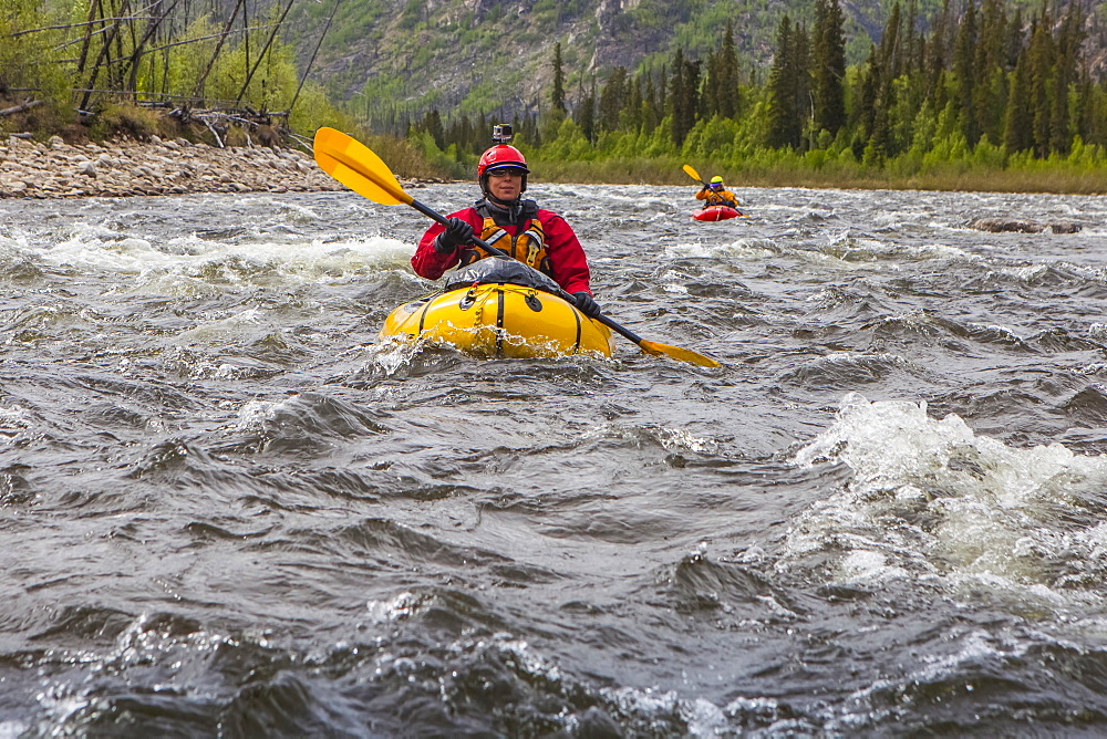 Two women packrafters negotiating a tributary of the Charley River in summertime, Yukon–Charley Rivers National Preserve, Alaska, United States of America