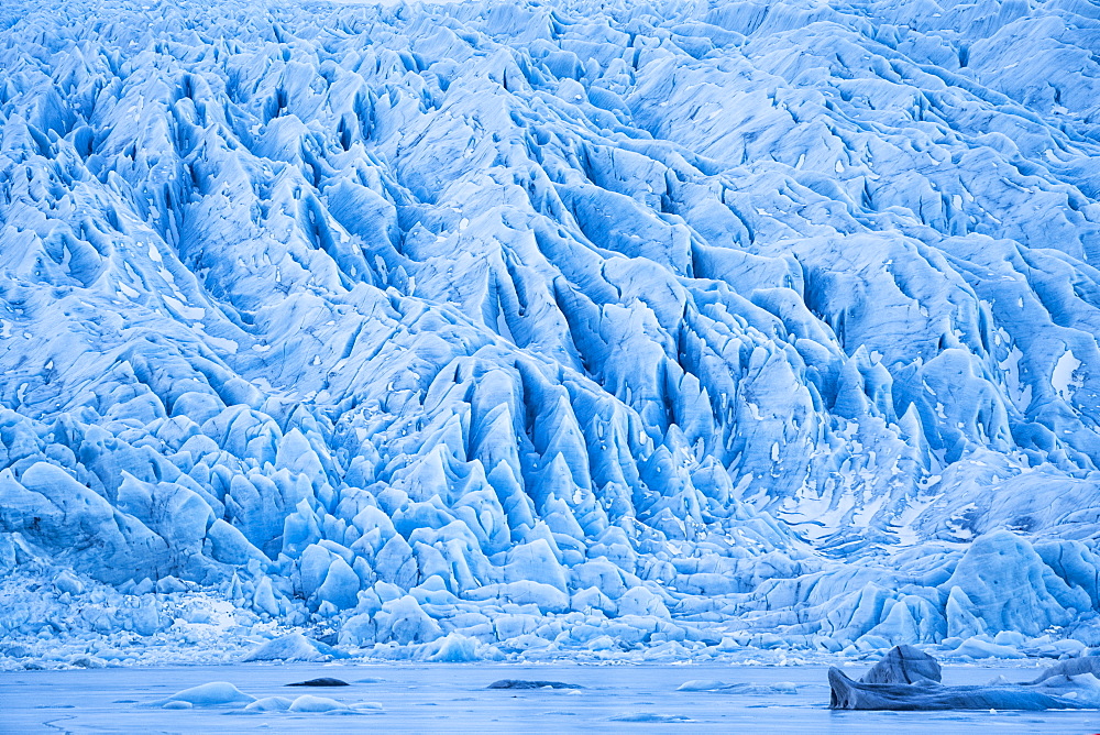 Glacier along the Southern shore of Iceland., icebergs are frozen into the lagoon at the base of it, Iceland