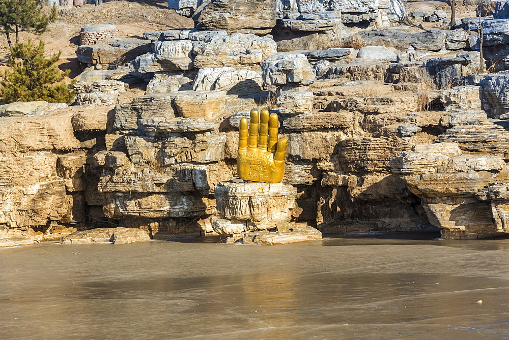 Buda hand along the frozen lake at Yungang Grottoes, ancient Chinese Buddhist temple grottoes near Datong, China