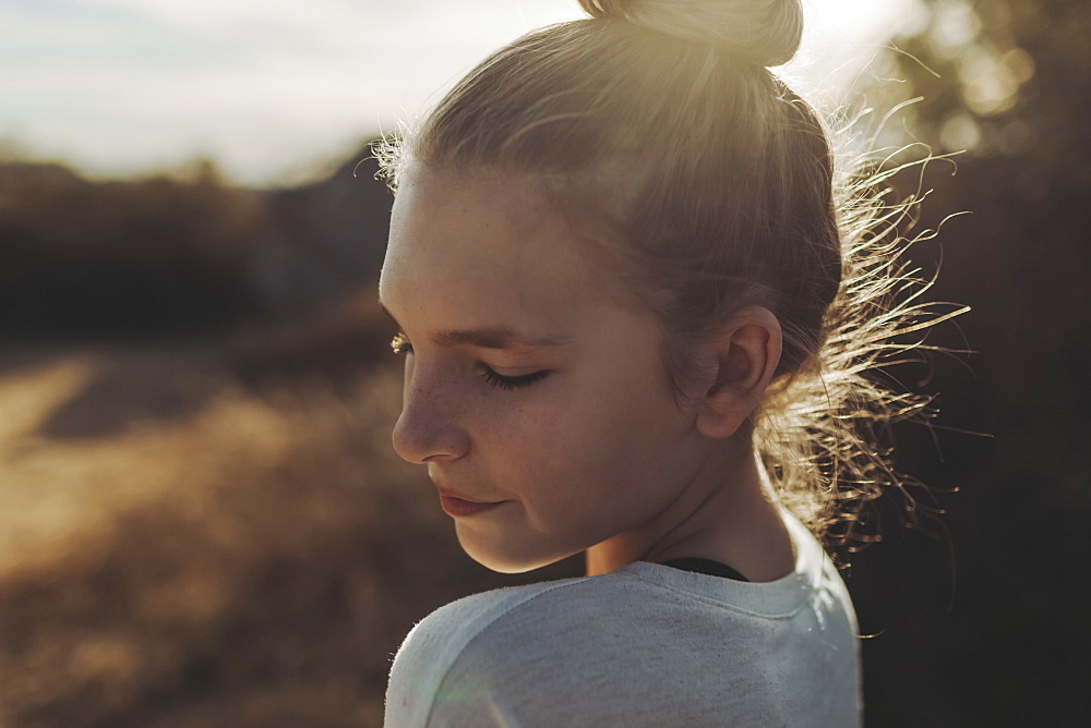 Close-up portrait of a preteen girl backlit by the sunlight, Los Angeles, California, United States of America