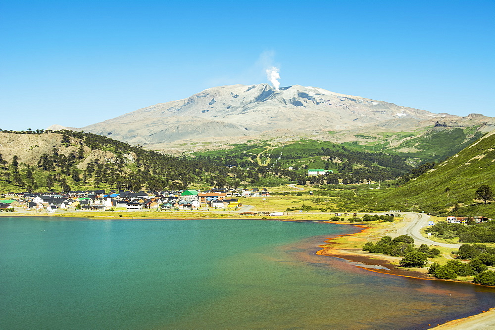 A small town on a lake shore with smoking volcano in the background, Cavahue, Neuquen, Argentina