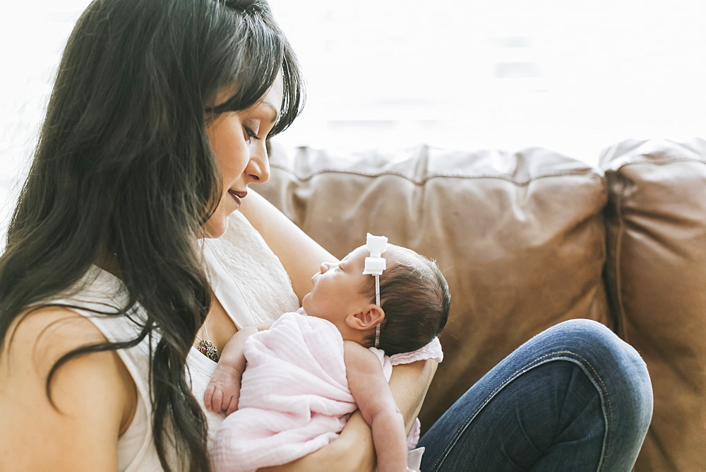 Newborn baby in mother's arms at home, Surrey, British Columbia, Canada