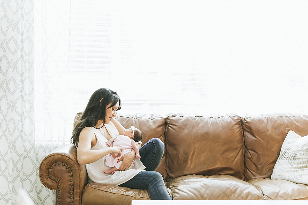 Newborn baby in mother's arms at home, Surrey, British Columbia, Canada