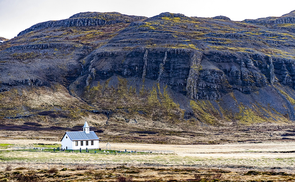 A church and small graveyard are dwarfed by the surrounding nature in Western Iceland, Iceland