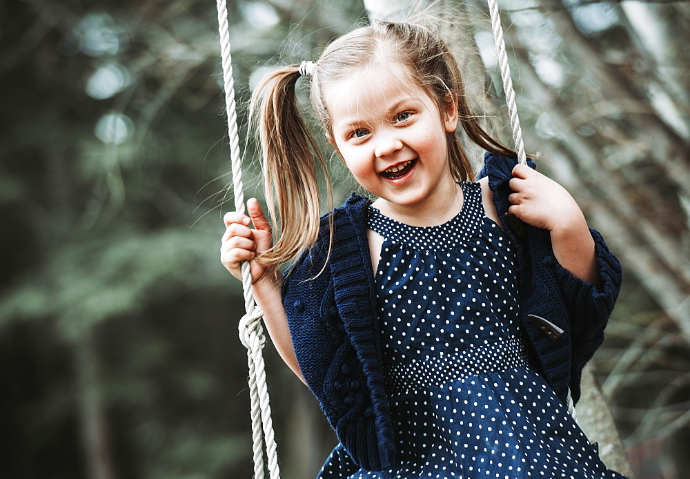 Portrait of a young girl swinging on a swing, Alberta, Canada