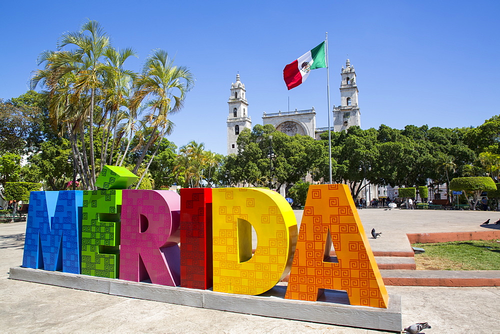 Colourful Merida sign with Mexican flag and Cathedral Of San Ildefonso in the background, Merida, Yucatan, Mexico