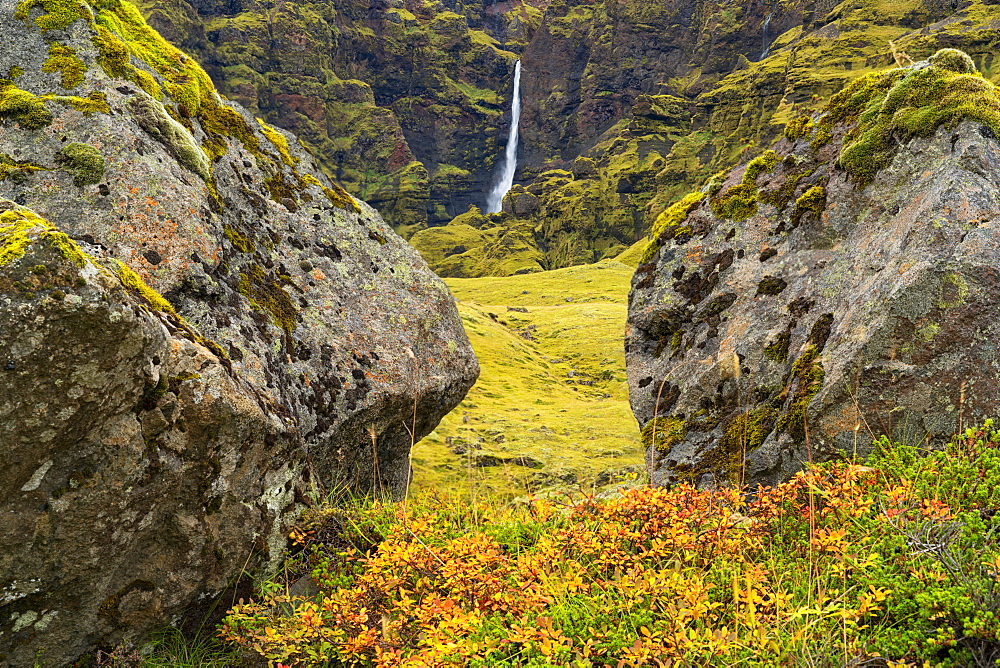 A large unnamed waterfall framed by large stone along the south coast of Iceland, Iceland