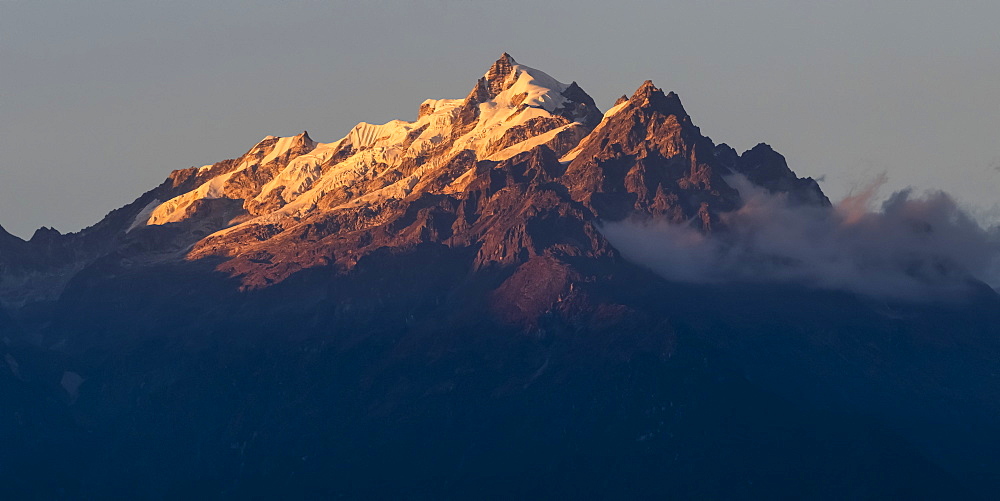 Sunlight illuminating the rugged peaks of the Kangchenjunga Mountain Range, a part of the Great Himalaya Range, Sikkim, India