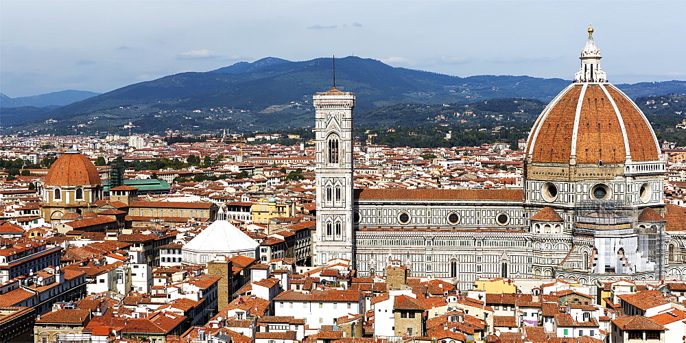 Panorama of the city of Florence with Florence Cathedral, it's dome and bell tower, and mountain range in the background, Florence, Tuscany, Italy