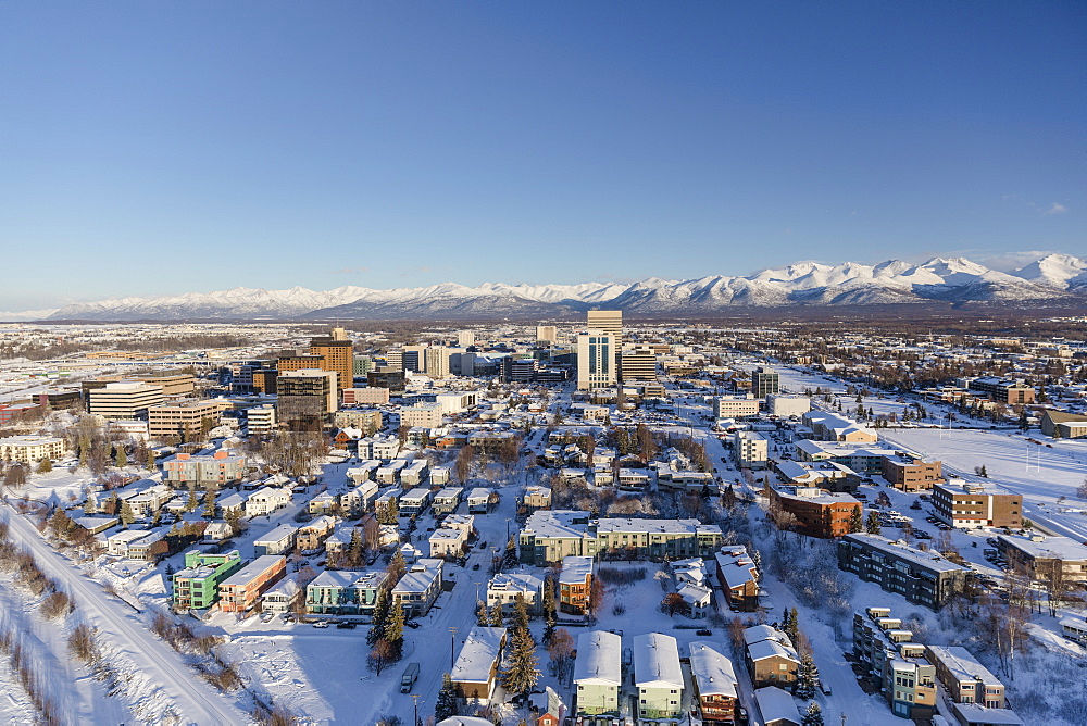 Aerial view of snow covering downtown Anchorage and the Chugach Mountains in the distance, the Park Strip and Capitan Cook Hotel visible in the foreground, South-central Alaska in winter, Anchorage, Alaska, United States of America