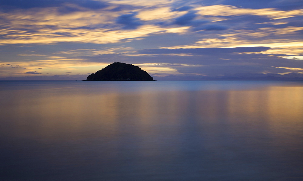 Beautiful sunrise reflected in the tranquil waters of the Pacific Ocean, Abel Tasman National Park, Nelson, New Zealand