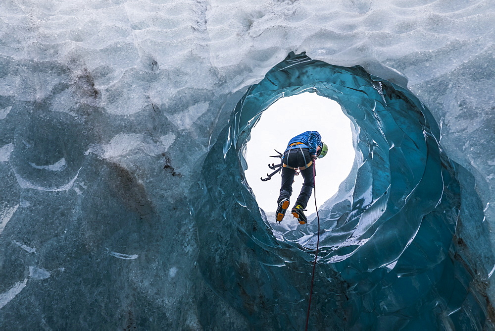 Man exploring an ice cave, South Coast, Iceland