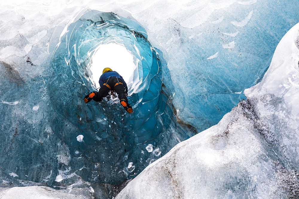 Man exploring an ice cave, South Coast, Iceland