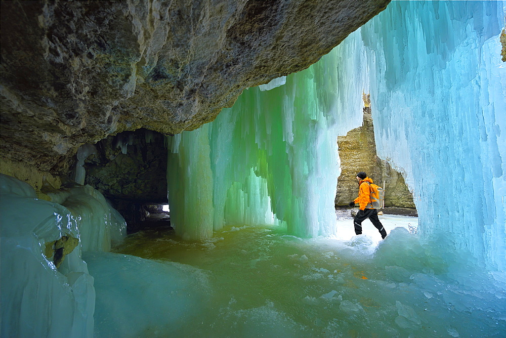 Exploring a canyon with frozen waterfall in winter, Jasper National Park, Alberta, Canada