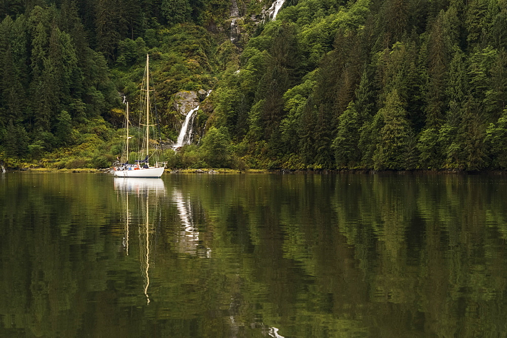 Sailboat in the Great Bear Rainforest with a waterfall along the coast, Hartley Bay, British Columbia, Canada