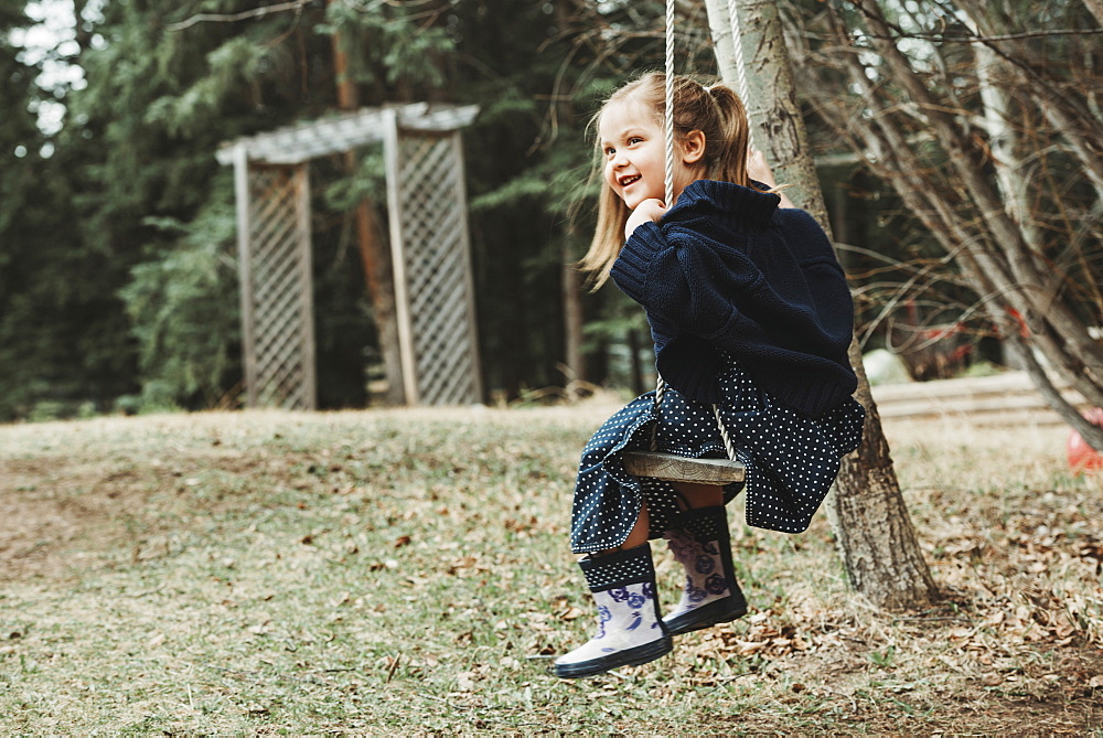 Portrait of a young girl swinging on a swing, Alberta, Canada