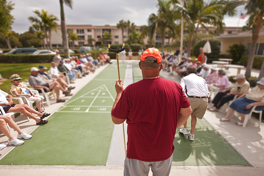 Spectators watching a shuffleboard game