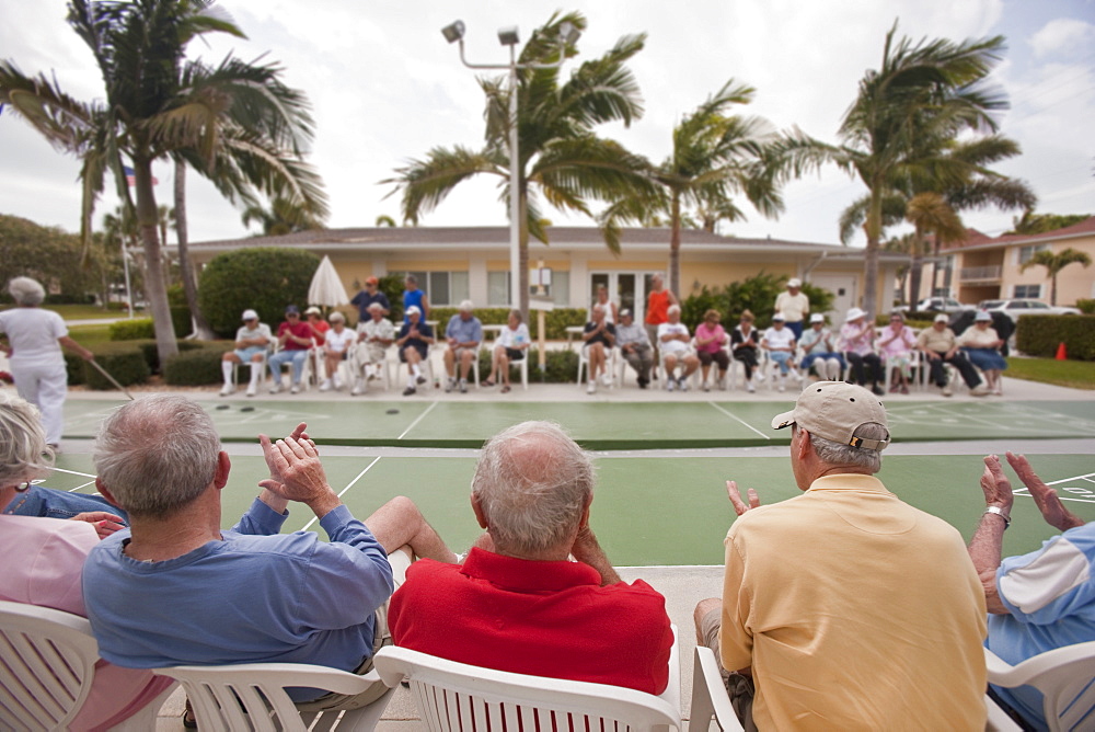 Spectators watching a shuffleboard game