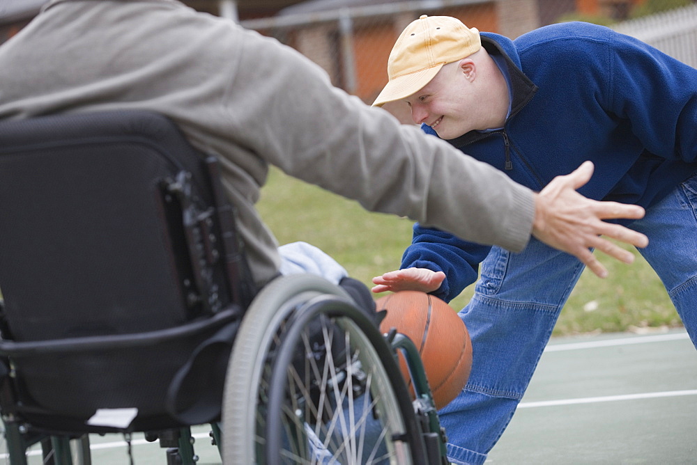 Disabled man playing basketball with his son Disabled man smiling with his son with Down Syndrome