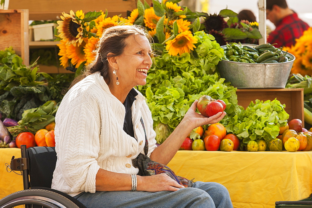 Woman with spinal cord injury in wheelchair shopping at outdoor market