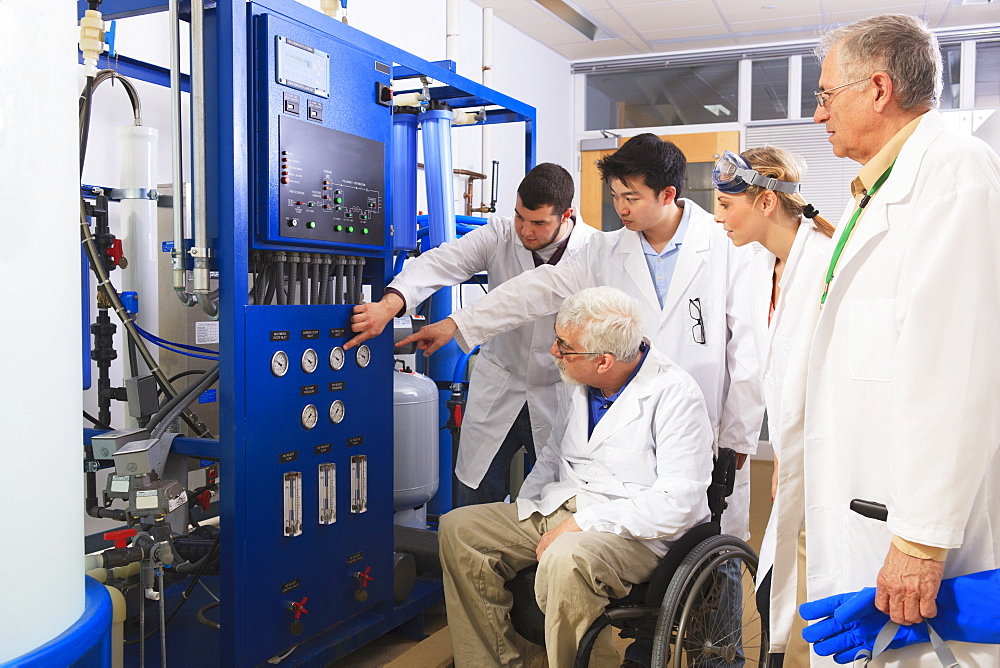 Professors explaining operation of water ultra purification system to engineering students in a laboratory