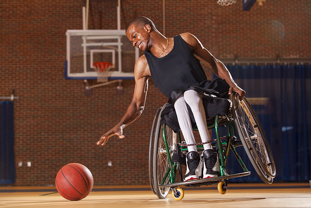 Man who had Spinal Meningitis in wheelchair reaching for basketball