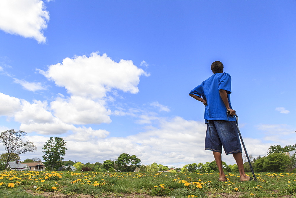 Man with Traumatic Brain Injury standing in a field of flowers