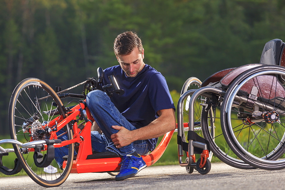 Man with spinal cord injury in his custom adaptive hand cycle getting into his wheelchair