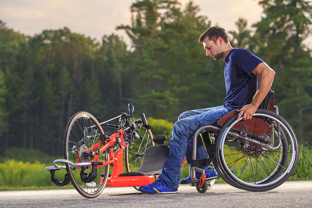 Man with spinal cord injury in his custom adaptive hand cycle getting into his wheelchair
