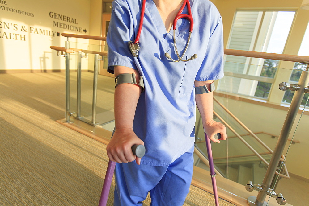 Nurse with Cerebral Palsy walking down the hallway of a clinic with her canes