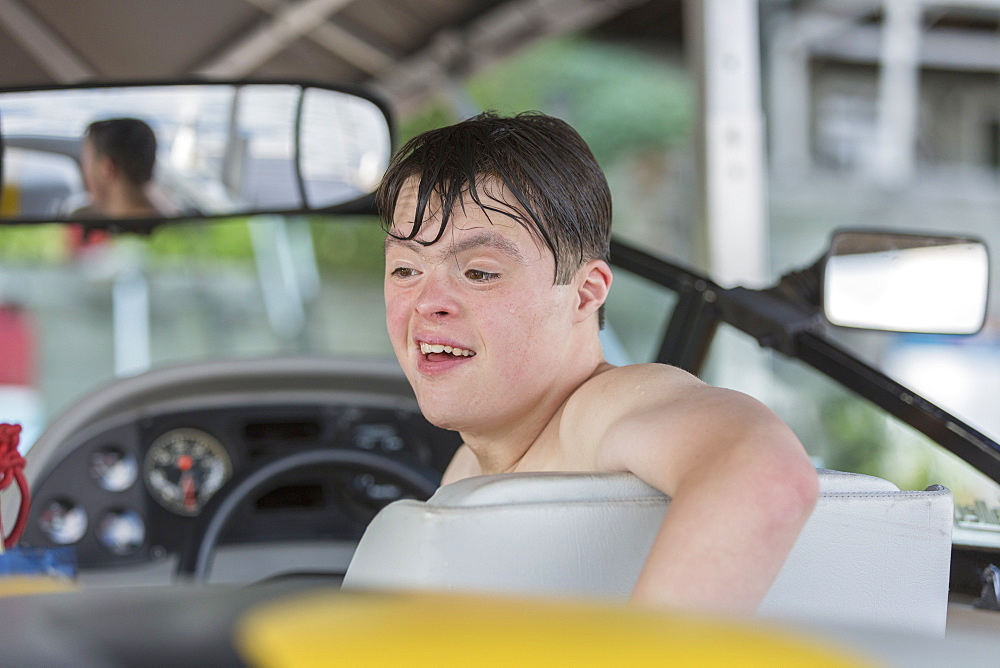 Young man with Down Syndrome riding in a boat