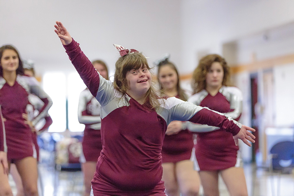 Cheerleader with Down Syndrome cheering with her friends