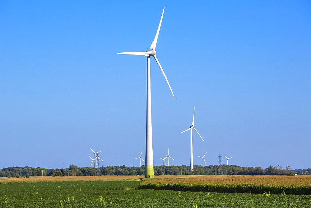 Wind turbines on farmland with a farm field in the foreground; Saint Remi, Quebec, Canada