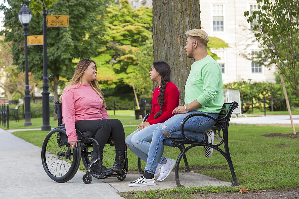 Woman who has Spinal Cord Injury talking with siblings in park