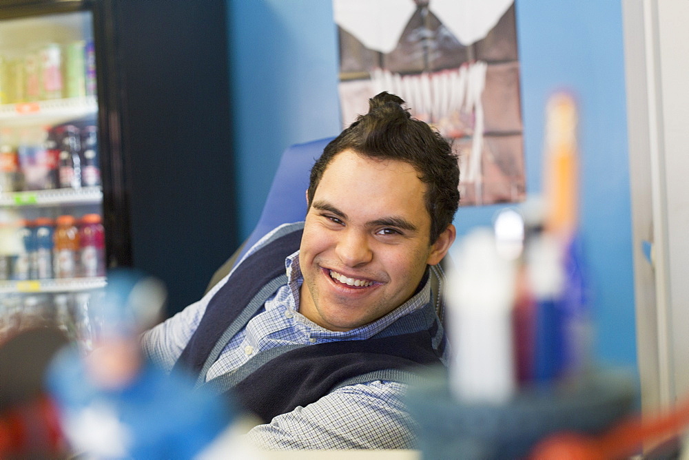 Middle Eastern man with Down Syndrome smiling at work