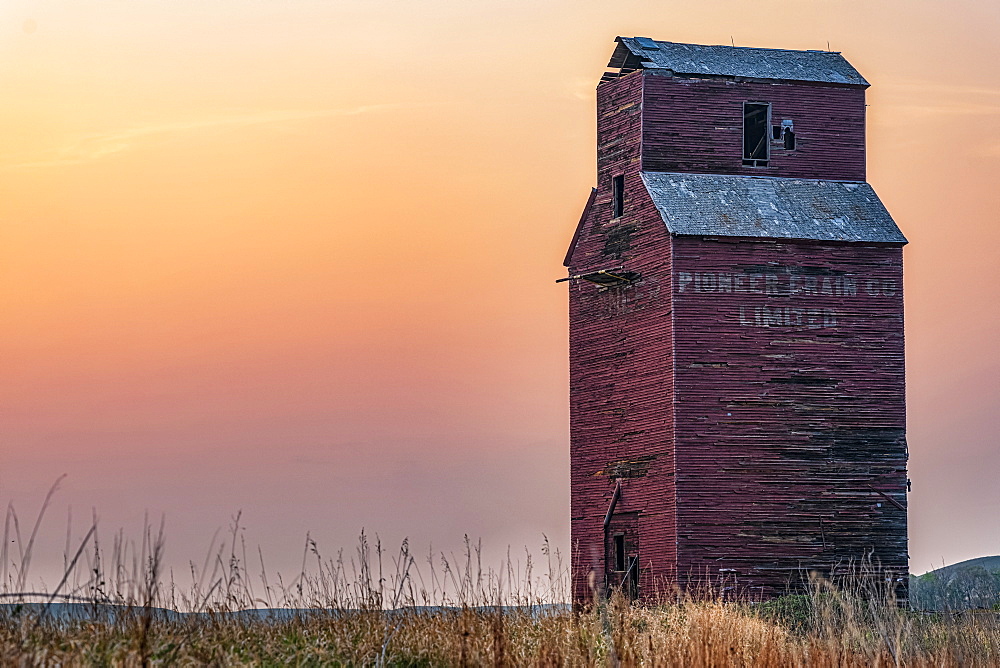 Abandoned and weathered grain elevator at sunset on the Canadian Prairies; Val Marie, Saskatchewan, Canada