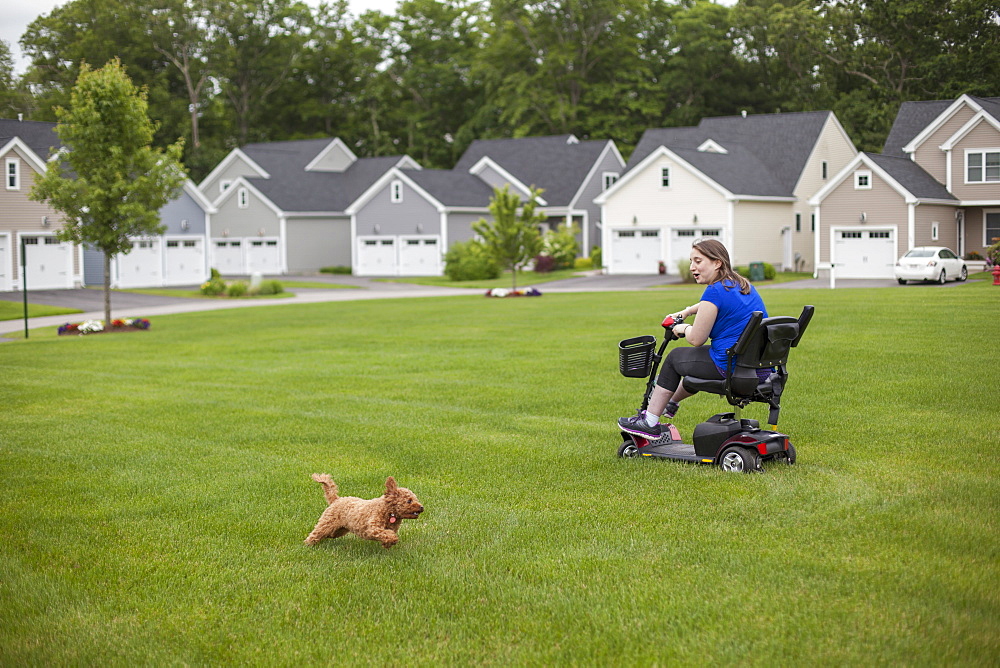 Young Woman with Cerebral Palsy riding her scooter on her lawn