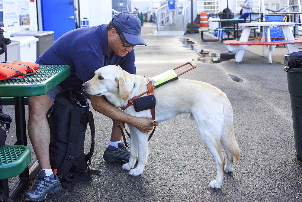 Blind man sitting with his service dog