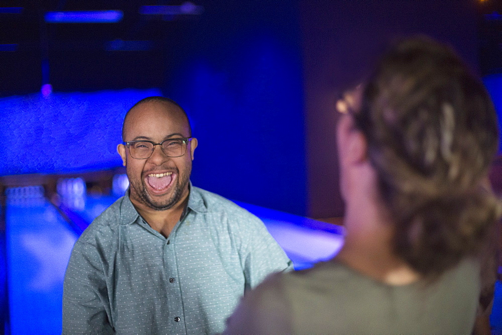 African American man who has Down Syndrome bowling with his friend