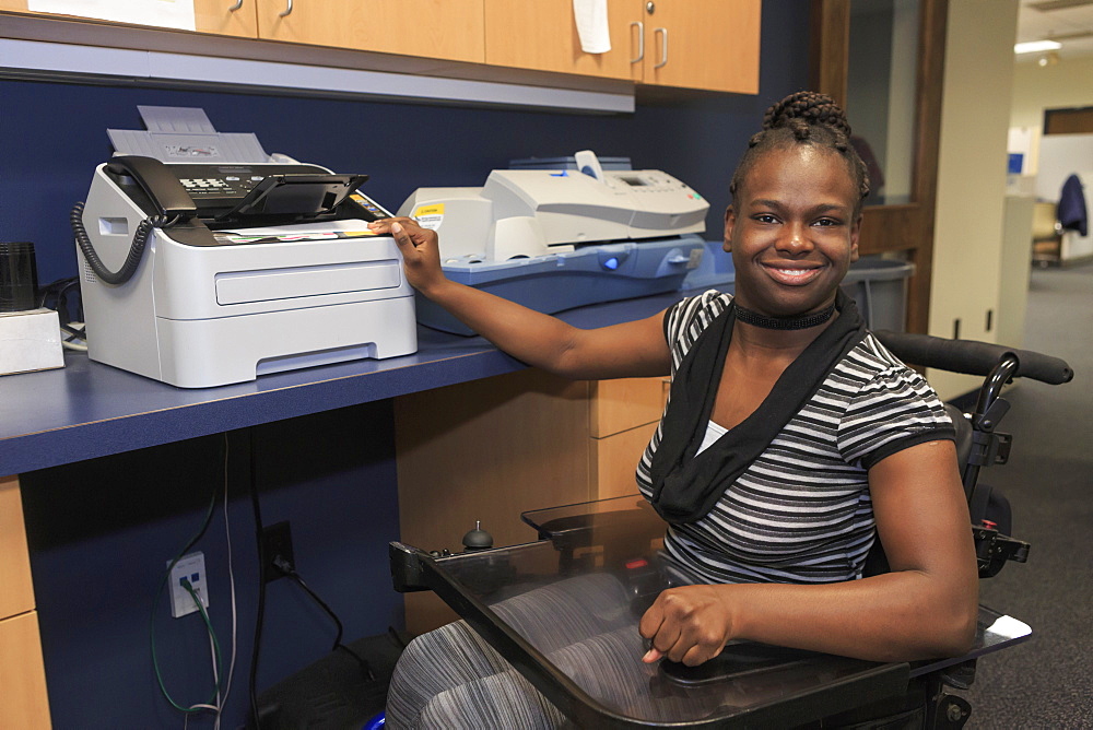 Teen with Cerebral Palsy using copier at office